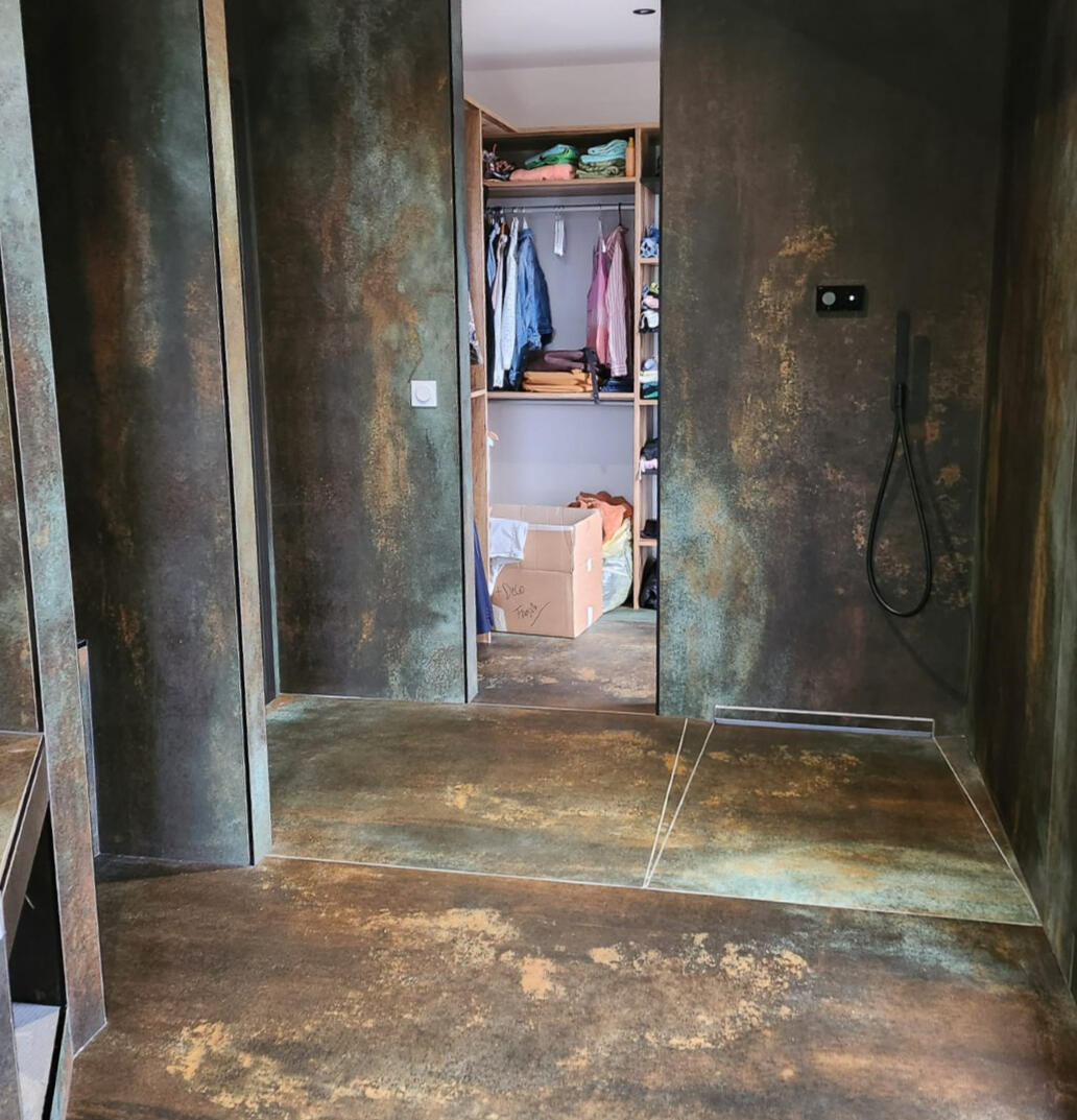Salle d’eau effet métal oxydé Habillage sur mesure en grès cérame effet métal oxydé, douche à l’italienne et dressing — création Nina Céramique